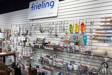 Frieling kitchen tools and accessories displayed on a wall, including kettles, utensils, and gadgets