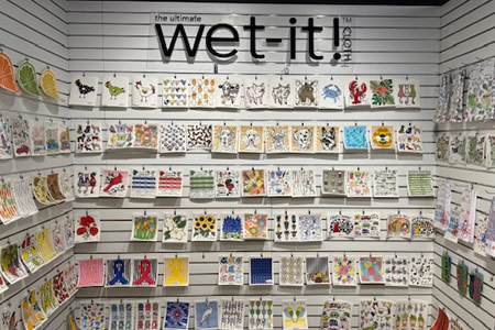 Wet-It reusable Swedish dishcloths displayed on a retail wall with assorted colorful patterns