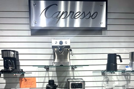 Capresso coffee makers and espresso machines displayed on glass shelving